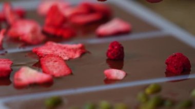 Erimiş çikolatayla doldurulmuş dondurulmuş ahududu kalıbına yakın plan. Çikolata üretim süreci. Yatay iç mekan videosu. Yüksek kalite 4k görüntü