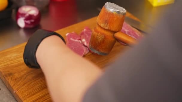 厨师用肉锤在准备猪肉嫩肉的木制切菜板上平猪肉片 — 图库视频影像