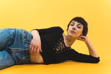 Yüzünde esrarengiz bir ifade ve gözleri kısmen kapalı bir şekilde yan yatarken orta ölçekli bir fotoğraf. Yüksek kalite fotoğraf