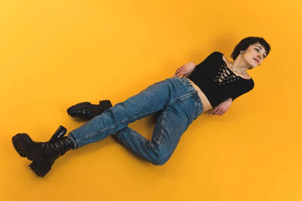 Γυναικείο Μοντέλο Ξαπλωμένο Στο Πάτωμα Μαύρη Μπλούζα Και Τζιν Πυροβολισμός — Φωτογραφία Αρχείου