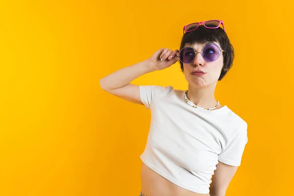 Medium shot of a woman in white top wearing two pairs of sunglasses - one on her nose and another on the top of her head. High quality photo