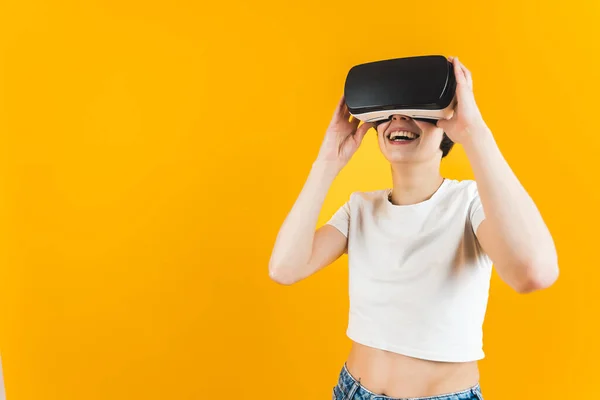 Vrouw Lachend Terwijl Een Virtual Reality Set Gebruikt Oranje Achtergrond — Stockfoto