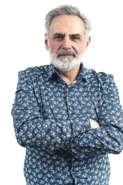 Mavi desenli düğmeli gömlekli, yaşlı, sakallı, gri saçlı bir adamın dikey çekimleri. Ciddi duruş. Çapraz kollar. Beyaz bir arka planda izole edilmiş. Yüksek kaliteli fotoğraf.. 
