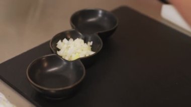 Şef kaseye doğranmış soğan ekler. Etli tartar hazırlamak - Polonya geleneksel mutfağı. Yüksek kalite 4K görüntü