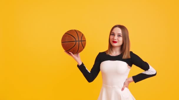 Młoda Biała Cheerleaderka Pozująca Koszykówką Rzucająca Nią Średnie Żółte Tło — Wideo stockowe