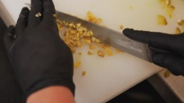 Şef mermer bir levhada turşu doğruyor ve geleneksel Polonya usulü sığır etli tartar hazırlıyor. Yüksek kalite 4k görüntü