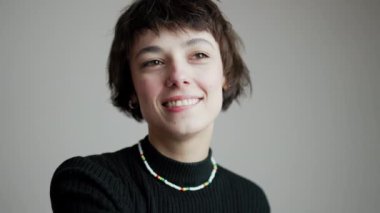 Gülümseyen bayan dansçı bir kolunu gri arka planda kameraya doğru uzatıyor. Stüdyo çekimi. - Evet. Yüksek kalite 4k görüntü