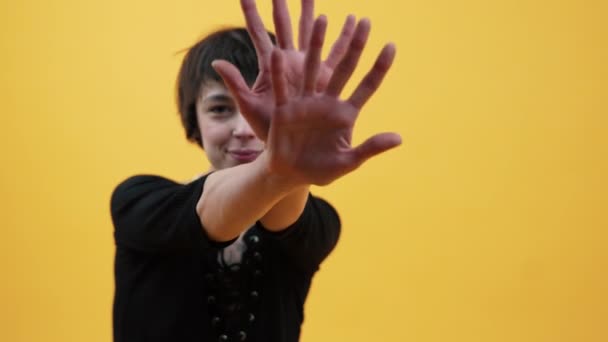 若い大人のスタイリッシュな女性は黄色の背景に彼女の手で踊ります カメラフォーカスを変更 コピースペース 高品質4K映像 — ストック動画