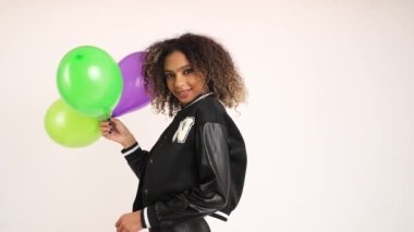 Beyaz arka planda elinde üç renkli balon tutan afro saçlı gülen kız. Yüksek kalite 4k görüntü