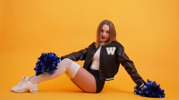 Ung Kvinna Cheerleader Poserar Med Blå Pompoms Orange Bakgrund Studio — Stockvideo