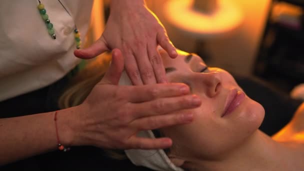 Kosmetikerin Gibt Einer Kundin Eine Entspannende Gesichtsmassage Mit Ihren Handflächen — Stockvideo