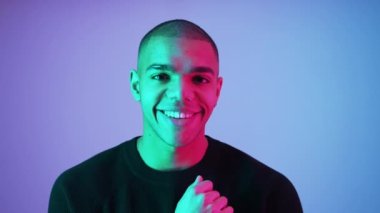 Arkadaş canlısı, olumlu bir adam kameraya hafifçe gülümsüyor. Pembe arka planda orta ölçekli yakın çekim stüdyosu. Genç yetişkin erkek model. Yüksek kalite 4k görüntü