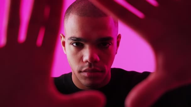 카메라 프레임 남자가 카메라를 손으로 분홍색 배경을 스튜디오에 있습니다 고품질 — 비디오