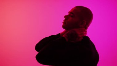 Sönük erkek silueti kameraya yan yan bakıyor ve neon pembe arka plana bakıyor. Yüksek kalite 4k görüntü