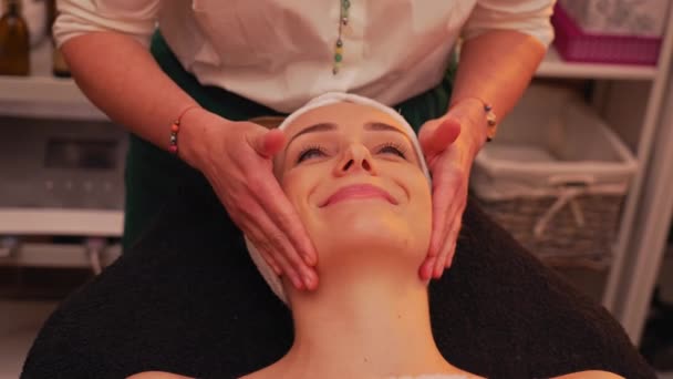 Therapist Doing Rejuvenating Facial Massage Happy Female Client Using Traditional — Stock Video