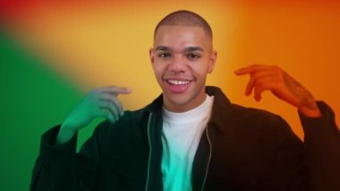 Kafasına dokunan ve sarı arka planda ağzını açan şaşırmış siyahi adamın portresi. Renkli Filtre folyoları. Yüksek kalite 4k görüntü