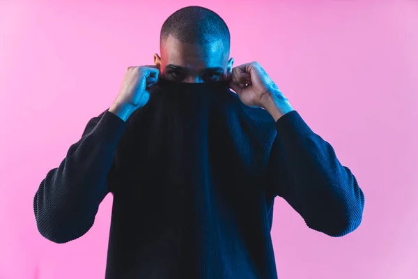 Αφροαμερικάνος Που Βάζει Πουλόβερ Στο Πρόσωπό Του Ροζ Φόντο Στούντιο — Φωτογραφία Αρχείου