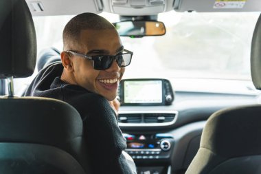 Şoför koltuğunda oturan gülümseyen Afrikalı Amerikalı adam kameraya bakıyor. Yüksek kalite fotoğraf