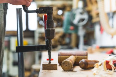 Carpenter stüdyosunun içi. Sıkı tutunun - manuel matkap, tokmak ve diğer geleneksel ahşap işleme aletleri kullanımda. Arka plan bulanık. Yüksek kalite fotoğraf