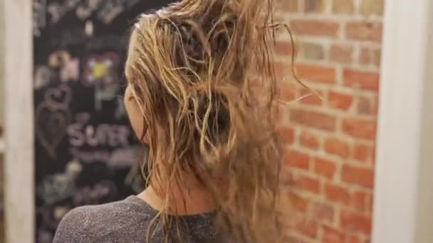 ヘアドレッサーはヘアカットの前に髪を準備する彼の女性のクライアントの濡れた髪を噴霧 高品質4K映像 — ストック動画