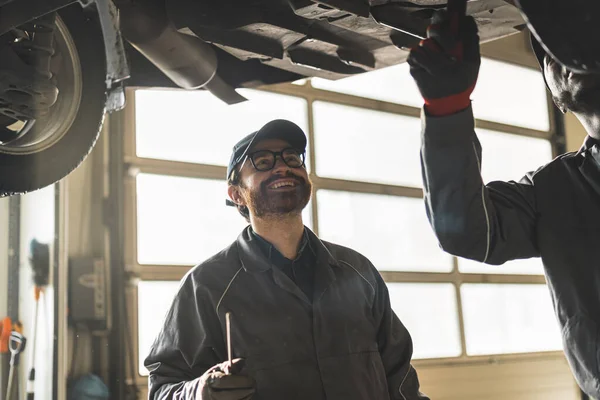 Mechanic Sunglasses Looking His Colleague Working Car Smiling Car Repair — Stock Photo, Image