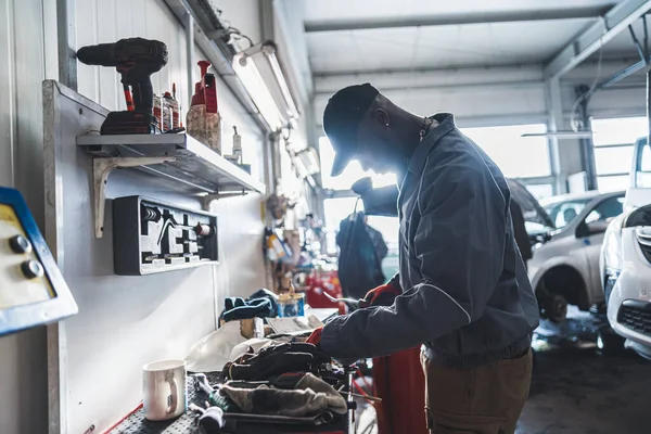 一个在车库里工作的非洲机械师的侧视图 中型射击机械师的概念 高质量的照片 — 图库照片
