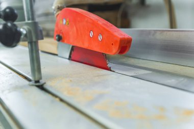 Masa testeresi ve turuncu bıçaklı korumanın yakın çekimi. Marangoz atölyesinde elektrikli marangozluk aletleri. Yüksek kalite fotoğraf