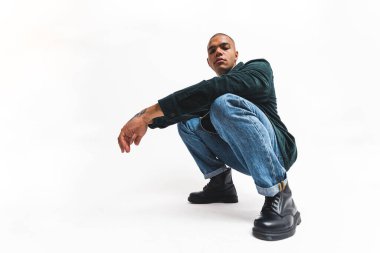 Beyaz arka planda izole edilmiş bir gangster gibi çömelmiş Afrikalı Amerikalı erkek model. Yüksek kalite fotoğraf