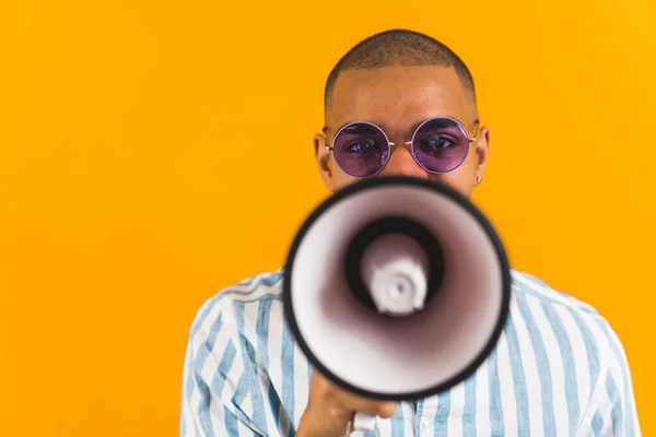 stock image Front view of a man hiding his face behind a megaphone on orange background. High quality photo