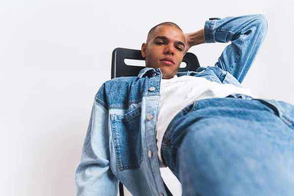 Ein Afroamerikanisches Männermodel Voller Jeans Liegt Auf Einem Stuhl Und — Stockfoto