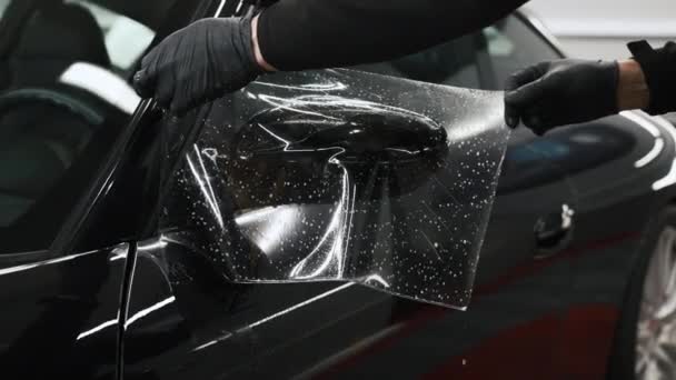 一对戴着手套的手把湿片保护膜放在汽车镜子上 高质量的4K镜头 — 图库视频影像
