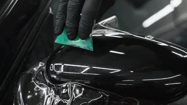 車のミラーに置かれた緑のスクレーパーTiスムーズに塗料保護フィルムを使用して バルク手袋の手のクローズアップ 高品質4K映像 — ストック動画