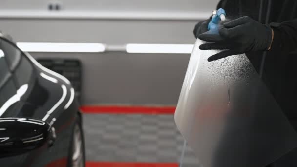 Μια Μεμβράνη Προστασίας Χρώματος Ψεκάζεται Νερό Πριν Τοποθετηθεί Ένα Αυτοκίνητο — Αρχείο Βίντεο