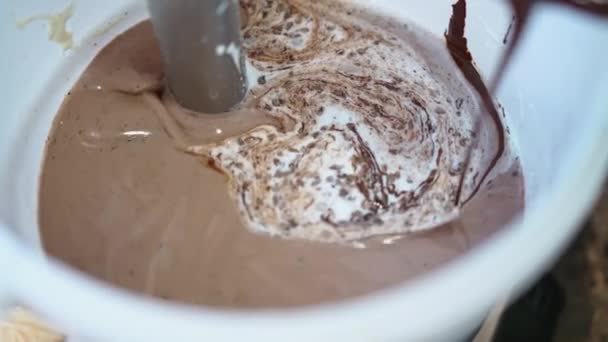 シェフはバケツのミキサーでそれを混合しながらアイスクリームにチョコレートを追加します 高品質4K映像 — ストック動画