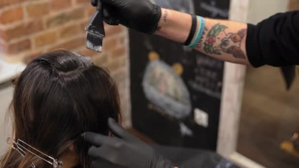 熟練した美容師は彼の女性のクライアントの髪の薄い層に髪のダイを適用します 高品質4K映像 — ストック動画