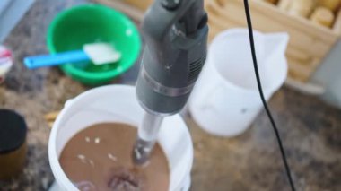 Malzemeleri karıştırmak için profesyonel blender kullanarak çikolatalı dondurma hazırlıyorum. Üst Manzara. Yüksek kalite 4K görüntü