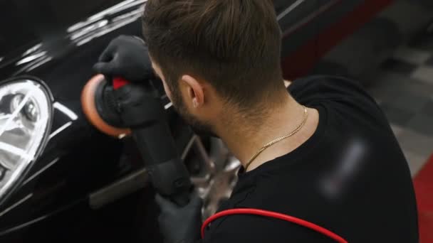 研磨機で黒い車を研磨する機械工の高角度ショット 中出しビデオ 高品質4K映像 — ストック動画