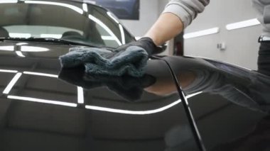 Siyah bir arabanın kaputuna seramik kaplama koyan bir kolun görüntüsü. Yüksek kalite 4k görüntü