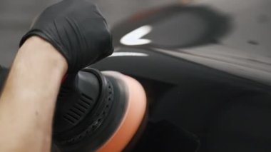 Erkek kolunun parlatıcısını cilalarken ve araba üzerinde kullanırken çekilmiş yakın çekim videosu. Yüksek kalite 4k görüntü