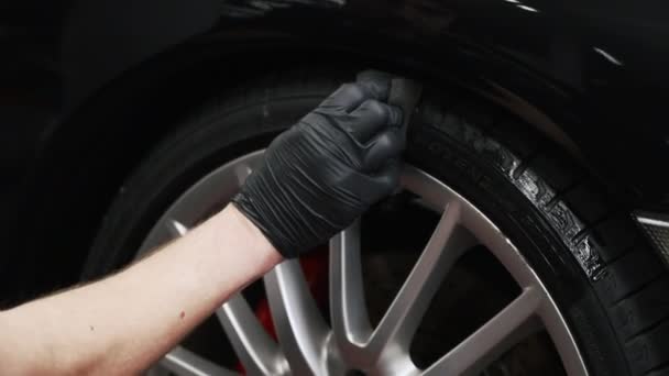 Sebuah Tangan Dalam Sarung Tangan Hitam Menggenggam Ban Mobil Dengan — Stok Video