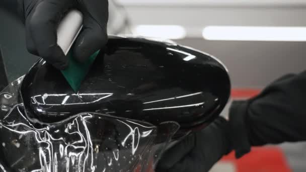 维修店的概念 油漆保护膜被贴在汽车的镜子上 并用刮胡刀擦亮 高质量的4K镜头 — 图库视频影像