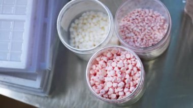 Mutfak tezgahında şeffaf kavanozlar ve küfler içinde renkli şekerleme sargıları. Üst Manzara. Yüksek kalite 4k görüntü