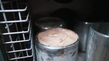 Çelik kaplarda dondurmalı dondurmalar, dondurma yapma süreci. Yüksek kalite 4k görüntü