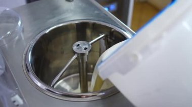 Fabrikadaki pastörizasyon makinesine vanilyalı dondurma ekliyorum. Yüksek kalite 4k görüntü