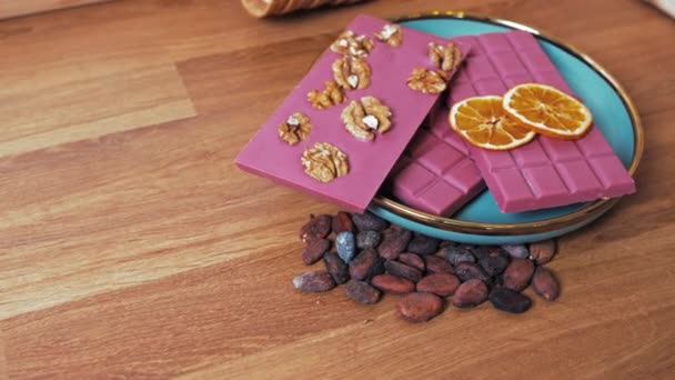 Barras Chocolate Rubí Con Rodajas Naranja Nueces Una Mesa Madera — Vídeos de Stock