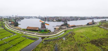 Zaanstad köyündeki su kanalındaki hakiki Zaandam değirmenlerinin insansız hava aracı panoraması. Zaanse Schans yel değirmenleri ve ünlü Hollanda kanalları. Yüksek kalite fotoğraf