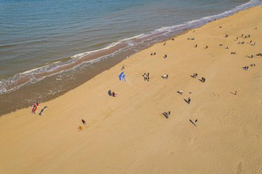 Bahar güneşli bir günde kumsalda dinlenen insanlar, hava çekimi. Kumsal ve güzel deniz. Yüksek kalite fotoğraf