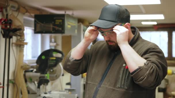 男木工戴上安全眼镜和耳罩 开始在车间工作 高质量的4K镜头 — 图库视频影像