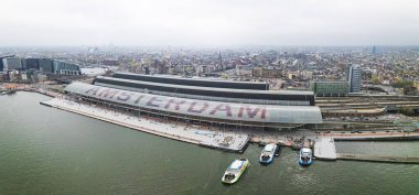 Hollanda, IJ nehri kıyısındaki Amsterdam Centraal Central Tren İstasyonu 'nun hava manzarası. Yüksek kalite fotoğraf