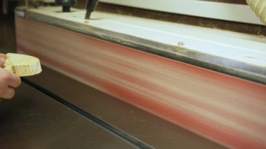 Marangoz bir atölyede öğütme makinesi kullanarak kalp şeklinde ahşap bir parçayı örüyor. Yüksek kalite 4k görüntü